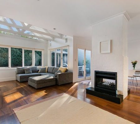 Sunlit living room with sectional sofa and fireplace